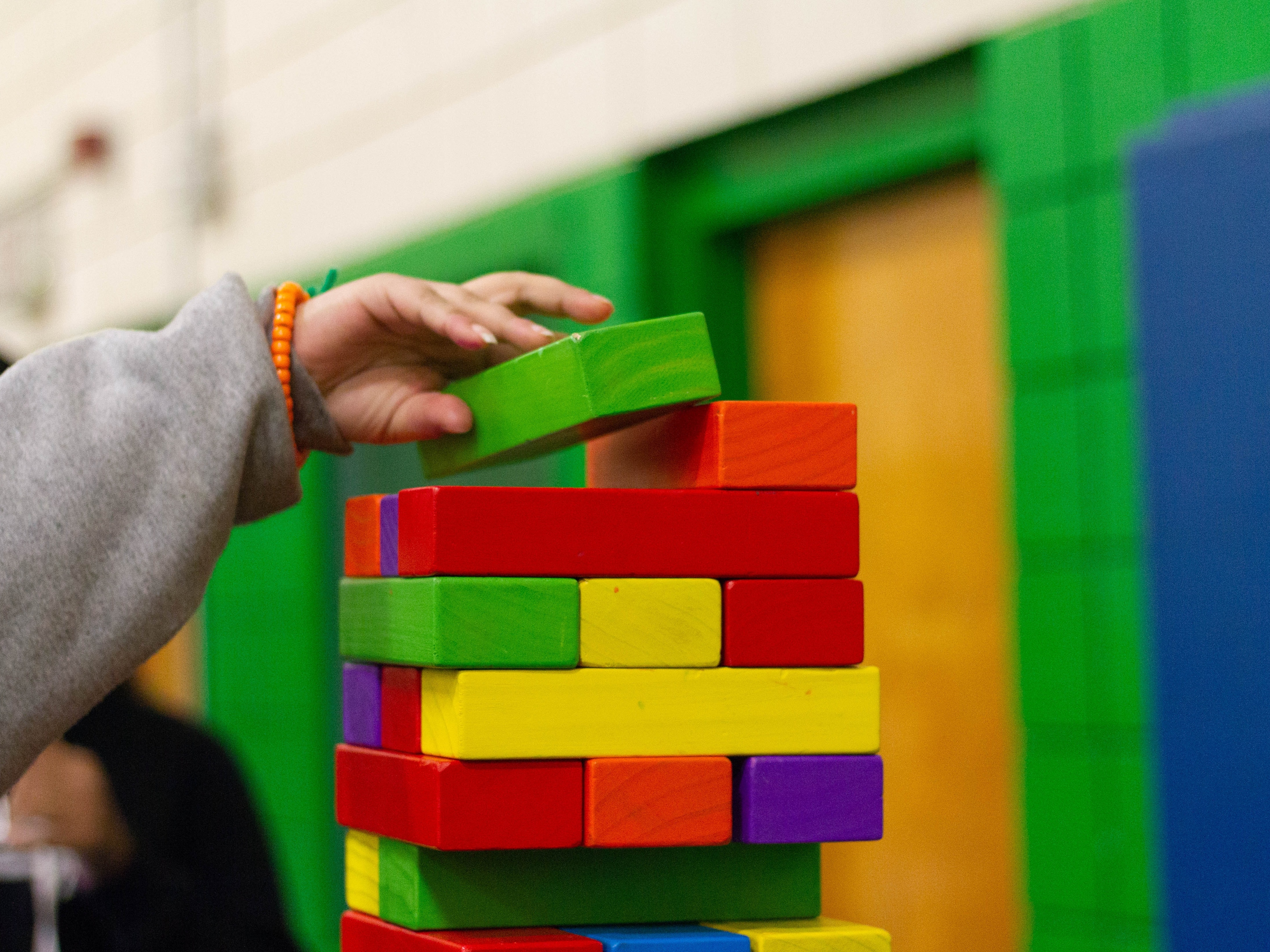 一个孩子正在搭建五彩缤纷的叠叠乐塔
