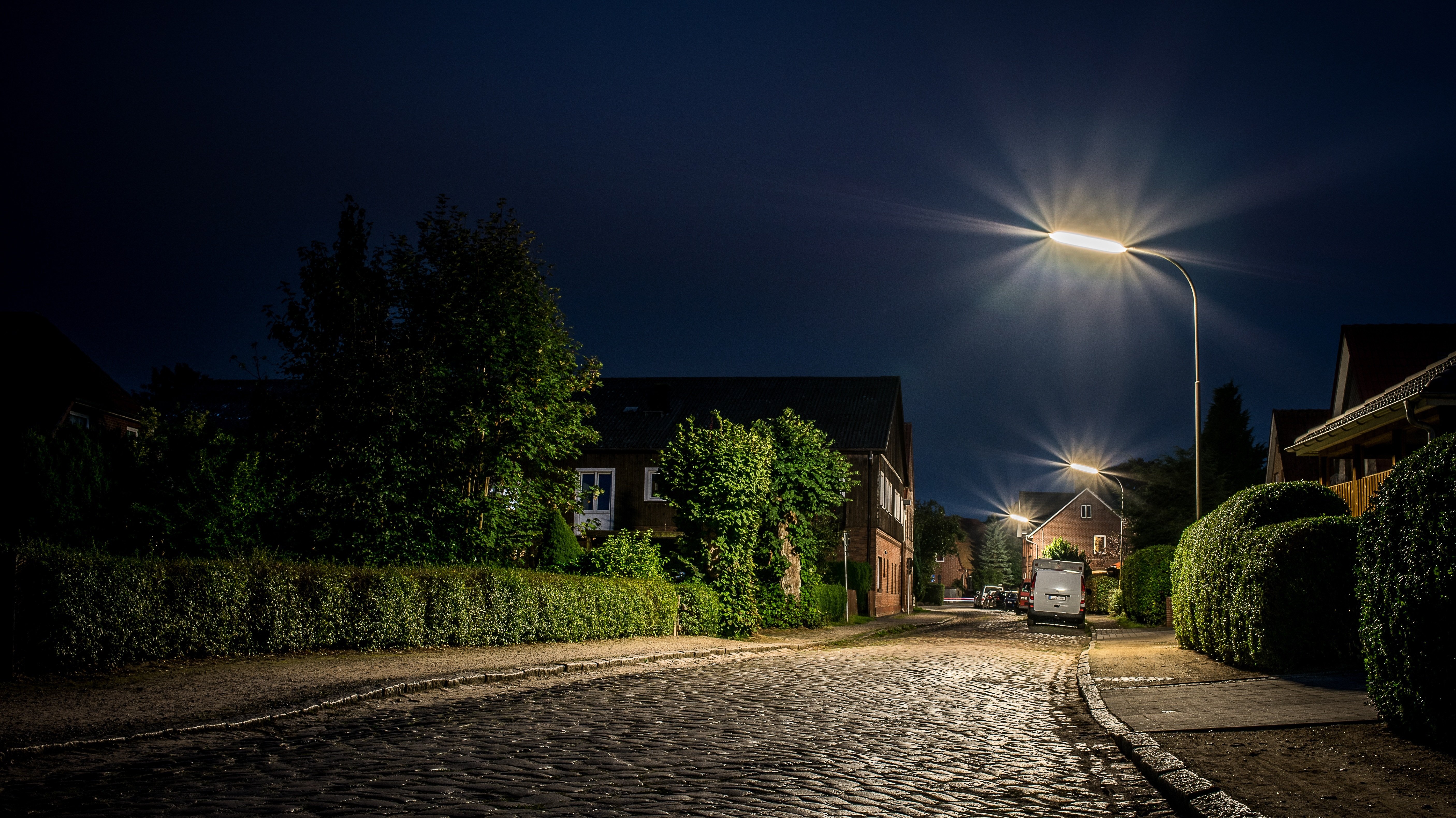 Street light illuminating houses and a cobbled street. 