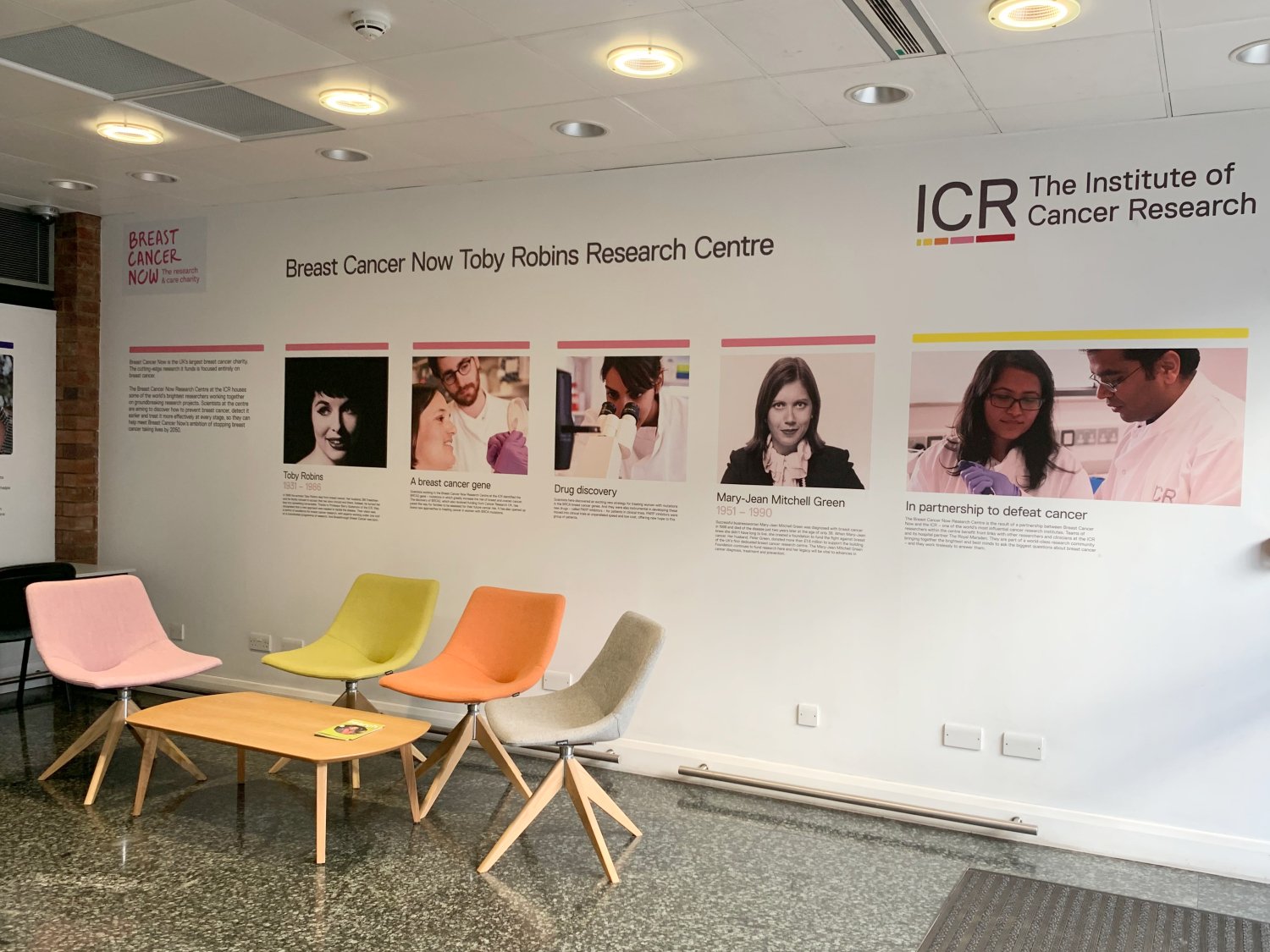 Breast Cancer Now wing seating area with colourful chairs and a timeline of the Centre on the walls