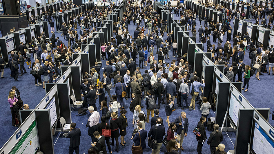 Crowd of people looking at various posters at ASCO 2018 conference 945x532px