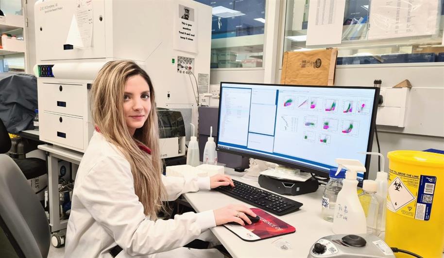Dr Vivian Dimou with a flow cytometry machine