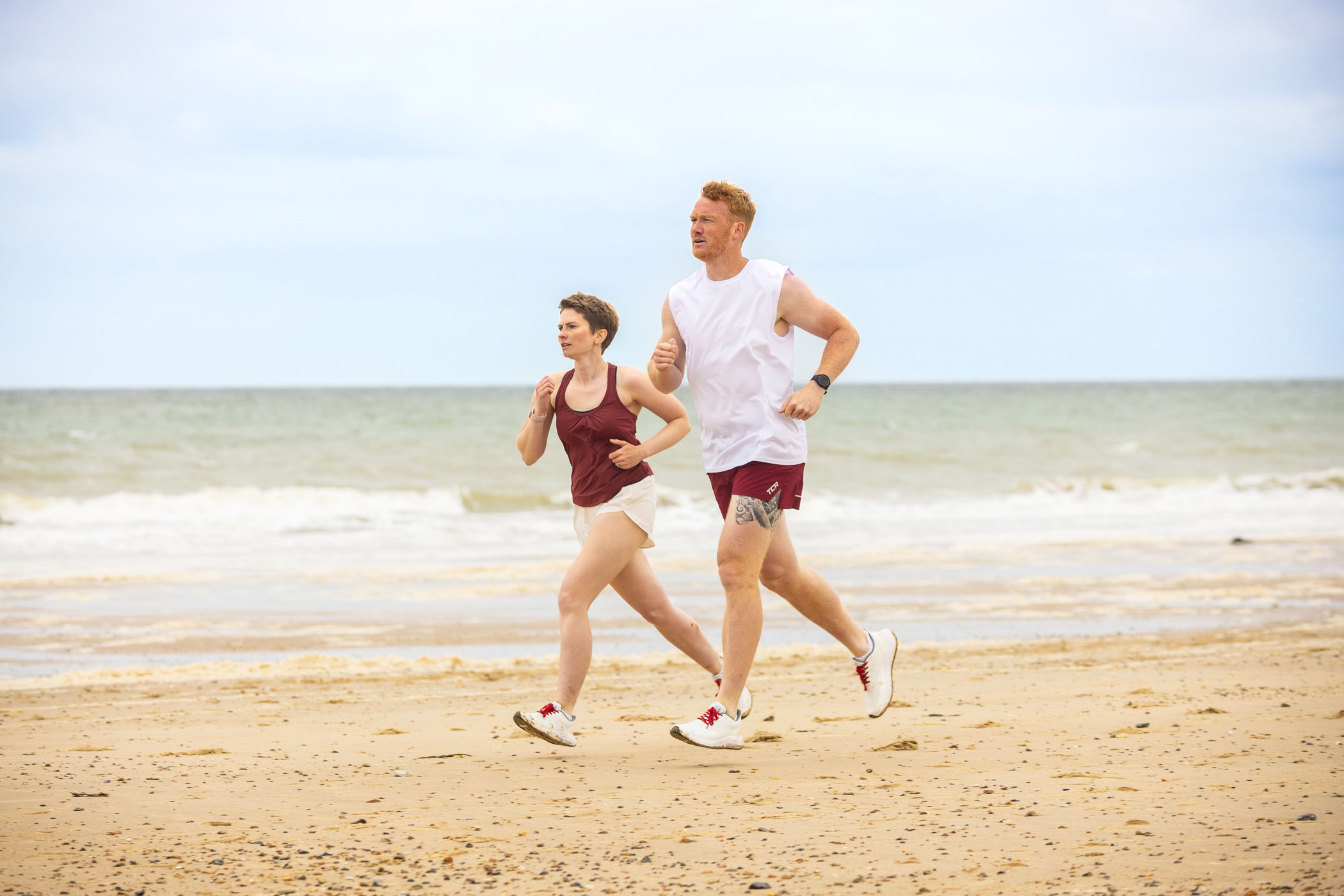 Greg Rutherford and Paralympic Erin Kennedy running on a beach