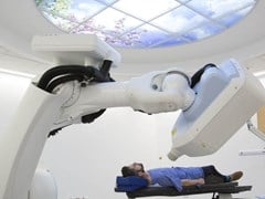 Patient lying in a robotic radiotherapy device called Cyberknife
