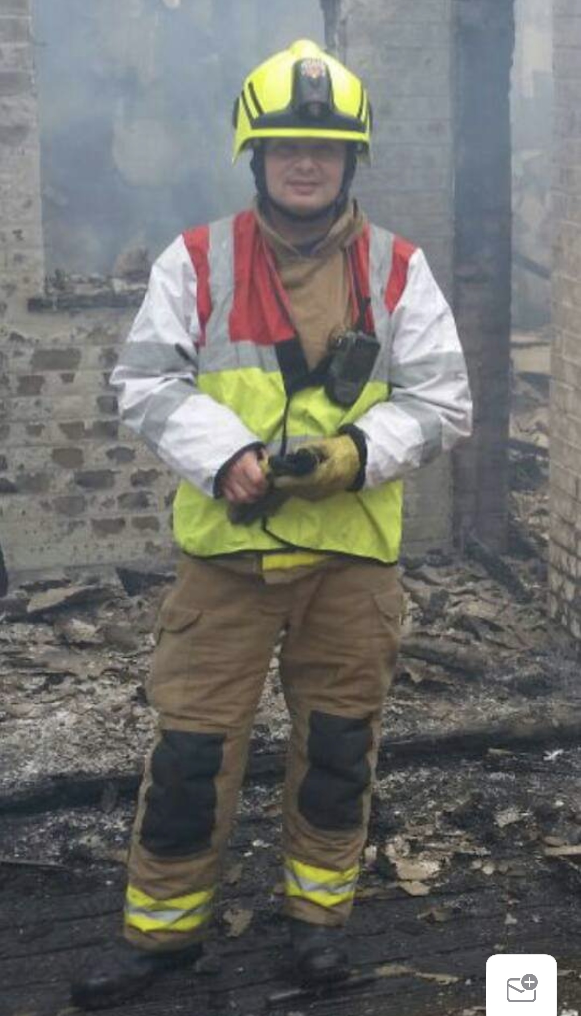 Harry wearing his firefighter uniform at the site of a fire