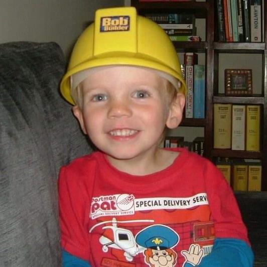 Lucas wearing a Bob the Builder hat and a Postman Pat top