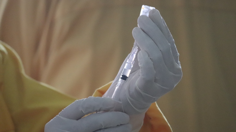 Person filling a syringe with Covid-19 vaccine