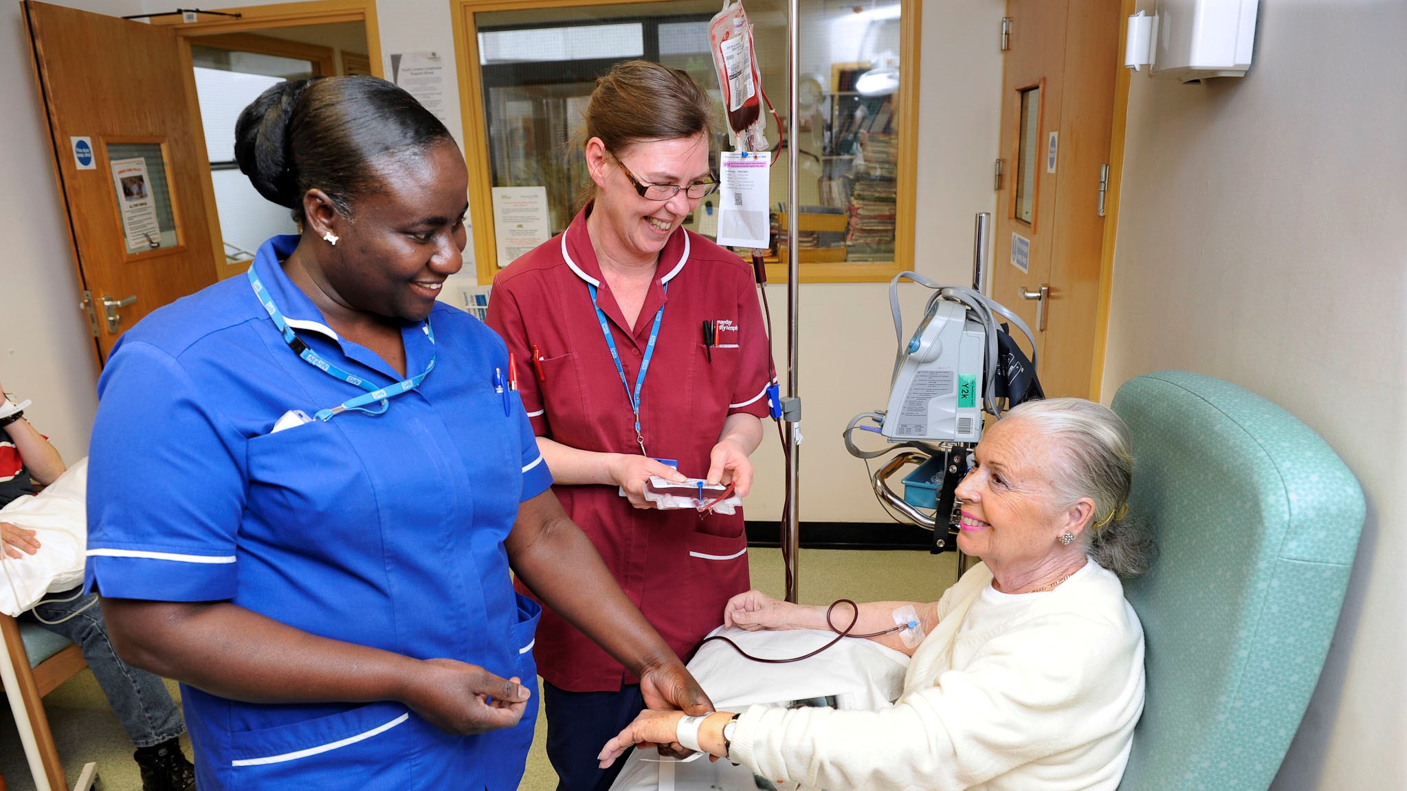 Elderly patient with two members of hospital staff