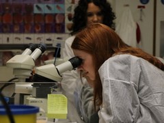 Two students looking into a microscope