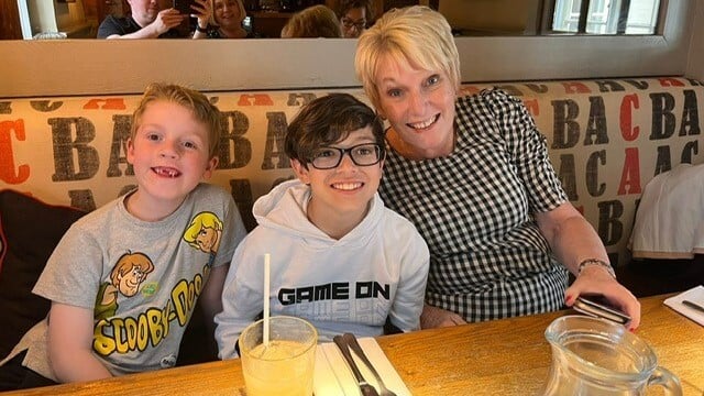 苏和她的两个孙子在一家餐馆外出用餐