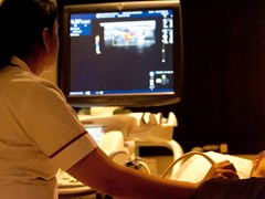 A nurse using ultrasound to image a region of a patient's body